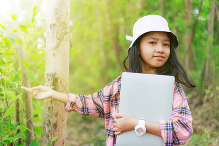 The little Asian girl holding tablet at the tropical farm, Little famer smile with happinessの写真素材