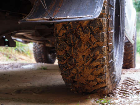 Dirty rear wheel of the off-road 4x4 truck at a countryside rural place in Rainy vibe, 4wd vehicle in rain, Selective focus shallow depth of fieldの写真素材