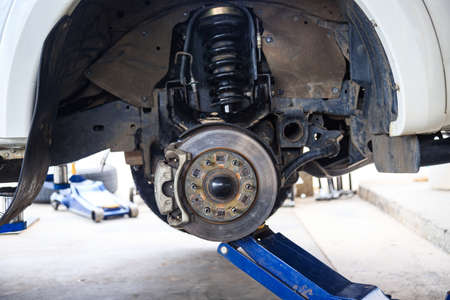 The wheel hub of the car with removed the wheel for brake and tire maintenance, the car jack lifting the car for serviceの写真素材