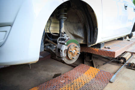 The wheel hub of the car with removed the wheel for brake and tire maintenance, the car jack lifting the car for serviceの写真素材