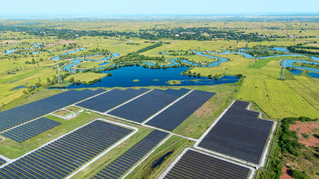 Drone shot aerial view solar energy array provides renewable power in large scale facility surrounded by greenery and water in rural place. Solar farm at the countrysideの写真素材