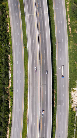 Drone shot aerial view multiple highway lanes in Thailand with few vehicles. Clean asphalt, green roadside, and minimal traffic convey efficiency and motionの写真素材