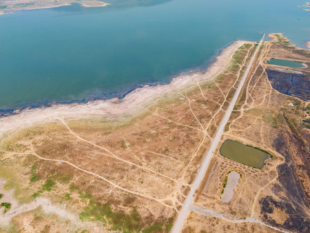 An aerial perspective captures a tranquil river surrounded by Lam ta khong Nakhon Ratchasima Thailand. An aerial perspective captures a tranquil river, winding paths, and small ponds. The landscape reflects nature's beauty and tranquility during daylightの写真素材