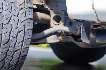 Closeup of a four-wheel drive pickup truck all-terrain tire showing worn tread patterns, dirt, and...