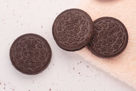 Three cookies consisting of two chocolate wafers with a sweet creme filling in betweenの写真素材