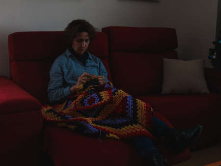 Middle aged woman sewing in her house