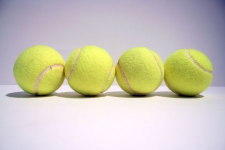four tennis balls in line の写真素材