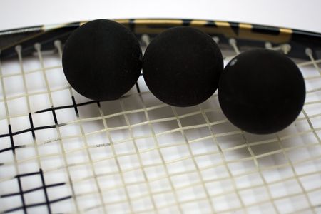3 squash balls on a racketの写真素材