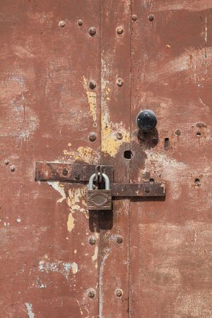 rusty metal door with padlock