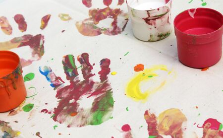 hand print and tubs of paint on canvasの写真素材
