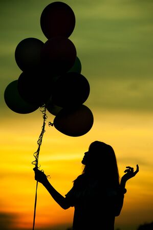 Silhouette of girl with balloon.の写真素材