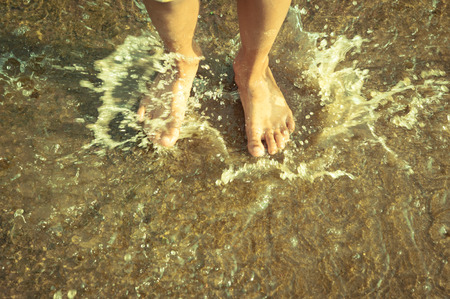 barefoot making big water splashの写真素材