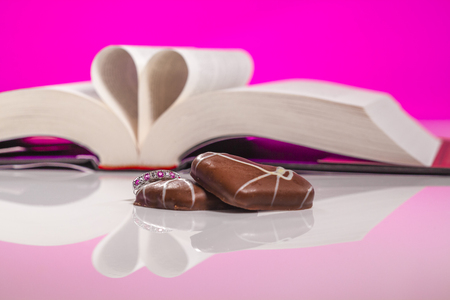 Book of love isolated on pink background. Love inspired stories show that faith, forgiveness and hope have the power to lift spirits and change lives, always.の写真素材