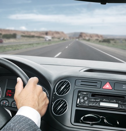 man is driving with hands on the steering wheelの写真素材