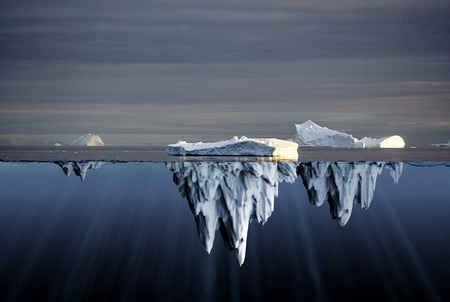 Above and below water view of icebergs in the Antarctica showing the volume of ice below the surface...