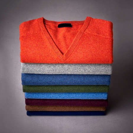 stack of sweater on a grey back ground
