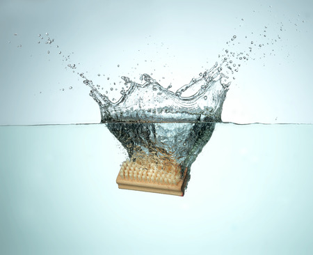 nail brush falling and splashing into water.の写真素材