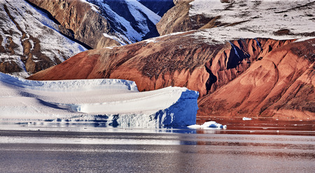 iceberg floating in greenland fjord.