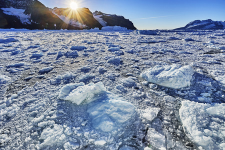 iceberg floating in greenland fjord.