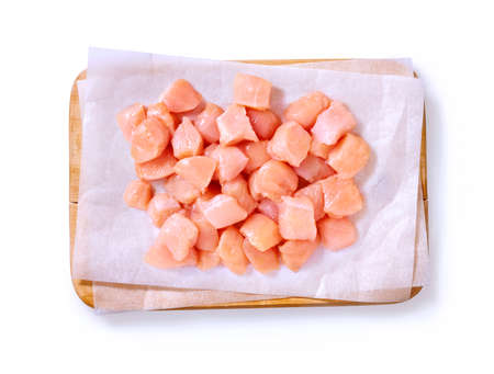 Pieces of raw chicken in a studio setting, on a wooden cutting boardの写真素材