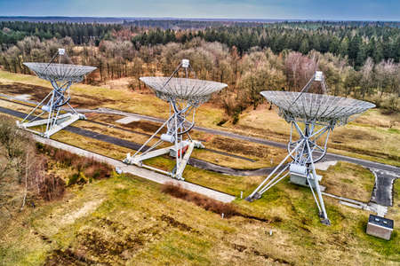outer space radio telescope array, with a forrest in the backgroundの写真素材