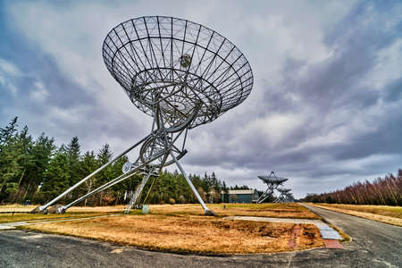 outer space radio telescope array, with a forrest in the backgroundの写真素材