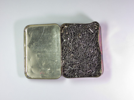 A tin box with shoe nails
