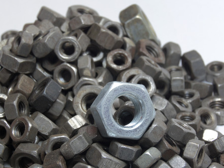 a pile of old nuts. Focus on the white hex nutの写真素材