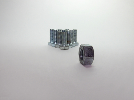 Bolts, arranged in a pyramid like bowling pins and nut in front of them, like a bowling ball