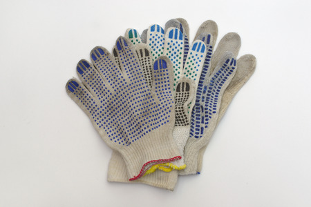 stack of cotton gloves with multicolored rubber dots, elastic cuffs, bordered by blue, red and...