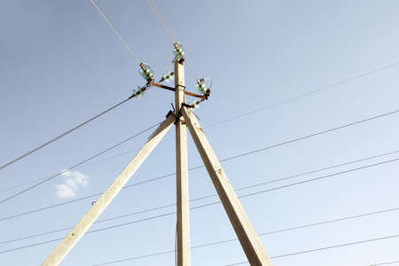 corner transmission tower of high voltage overhead power line. strain glass insulators, consists of assembly of suspension insulators, suspension strings, wires against blue skyの写真素材