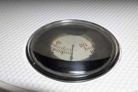 rotating measuring scale of analog bathroom scales with white ribbed surface. closeup. determing...