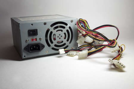 computer ATX power supply unit rear side, with fan and line power socket. colored power cords for...