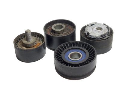 tensioner, idlers, pulleys of car actuators of engine and alternator. worn out rollers of car drive mechanisms, dismantled, repair reason. on white backgroundの写真素材