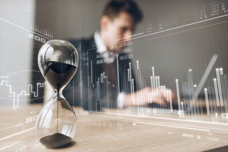 Image with a business graph and a chart on which businessman looking for some information on laptopの写真素材