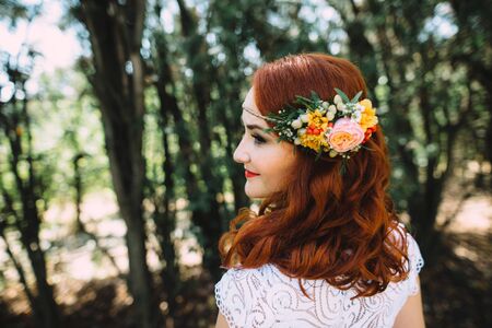 Portrait of a beautiful red-haired bride with flowers in her hairの写真素材