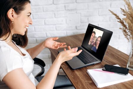 Young girl communicates online via video conference with her friends using a laptop at home. Video callの写真素材