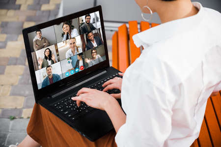 Back view of a student girl laptop by a video call.