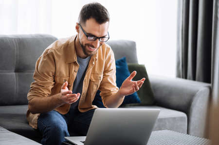 Smart male freelancer using laptop, have a video call, communicate with colleagues or friends by...