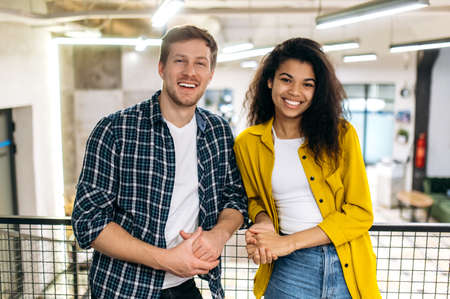Portrait of business coworkers or student friends. Handsome caucasian man and beautiful african...
