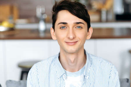 Close-up portrait of a handsome attractive blue-eyed caucasian guy, student or freelancer. Stylish...