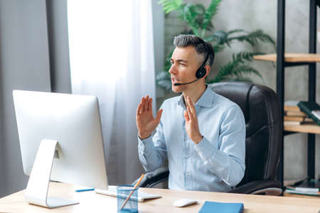 Confident caucasian middle-aged man, in formal stylish clothes and headset, business leader or ceo,...