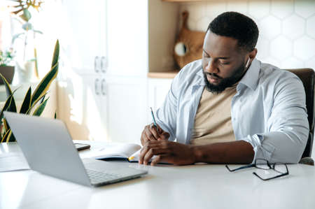 Concentrated successful serious African American bearded man, business leader, manager student, in...