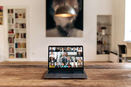Online virtual business meeting. View at laptop screen with adult intelligent influential caucasian businessman or coach conducts video meeting, business briefing with successful multiracial partnersの写真素材