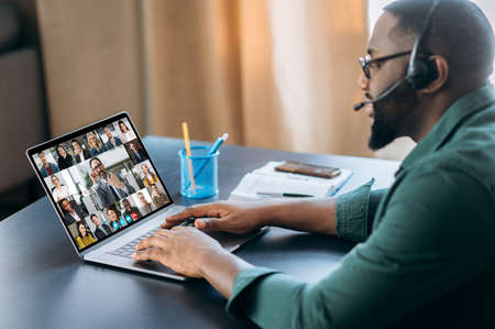 Successful African American man uses an application for online video communication with colleagues...