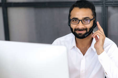 Head shot of a successful confident Indian man, operator of call center or business mentor....