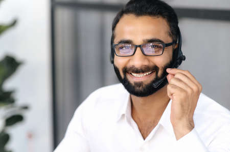 Close up head shot of intelligent Indian man, businessman, call center operator or consultant,...
