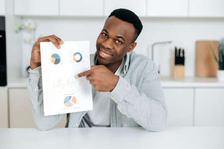 Headshot of successful smart attractive businessman, manager, or financial mentor, presents a graph, talks about a strategy and work plan during video conference, looks at the camera, smiles friendlyの写真素材