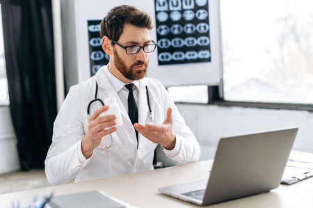 Online doctor consultation. Confident smart attentive caucasian male doctor conducts a consultation...