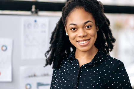 Portrait of a positive pretty, successful business woman of African American nationality, manager,...